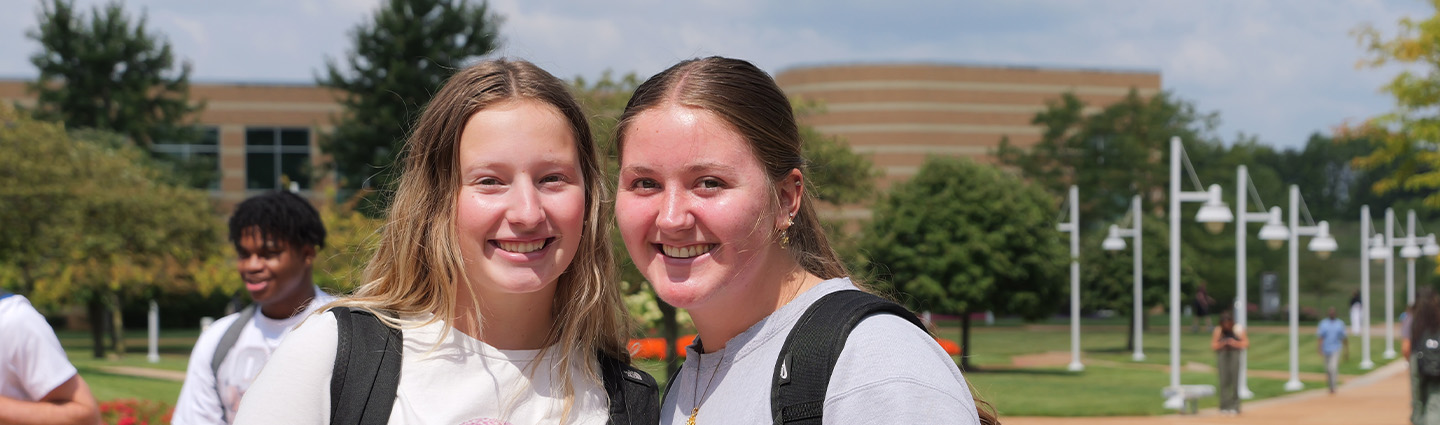 Two Female Students on First Day of Classes Smiling as They Walk to Their Next Class